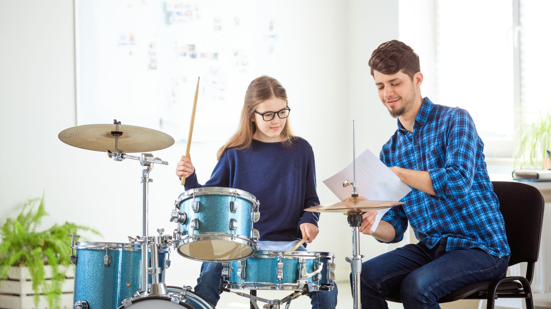 a red drum set with cymbals on a white background