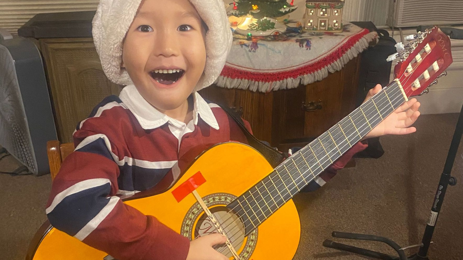 a black electric guitar with brown strings on a white background